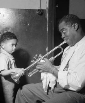 Louie Armstrong with young fan backstage getty images